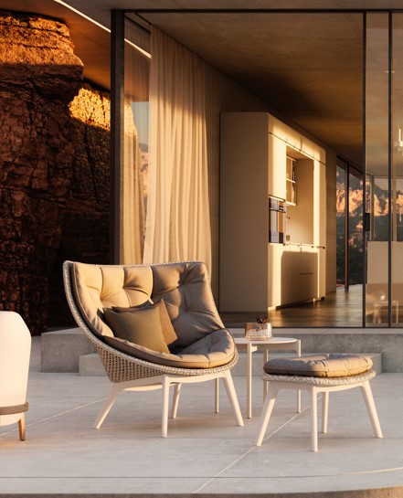 Moderne buitenstoelen bij glazen villa in zonlicht.