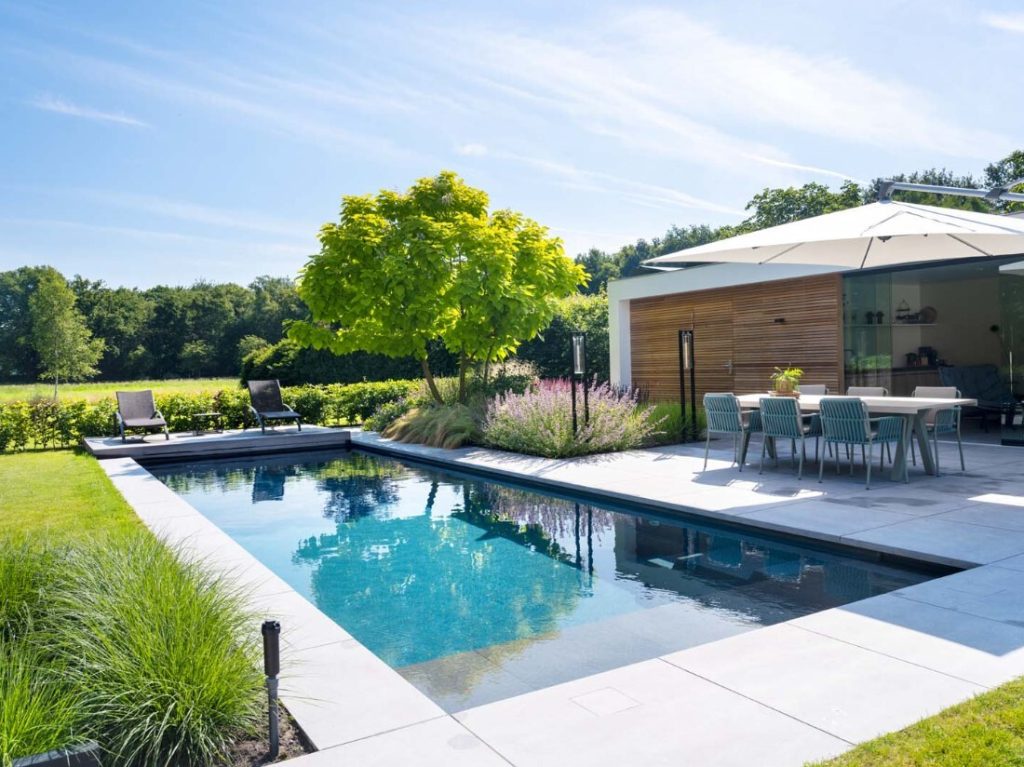 Moderne tuin met zwembad en terrasmeubilair