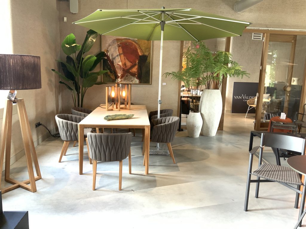 Moderne eetkamer met groene parasol en kamerplanten.