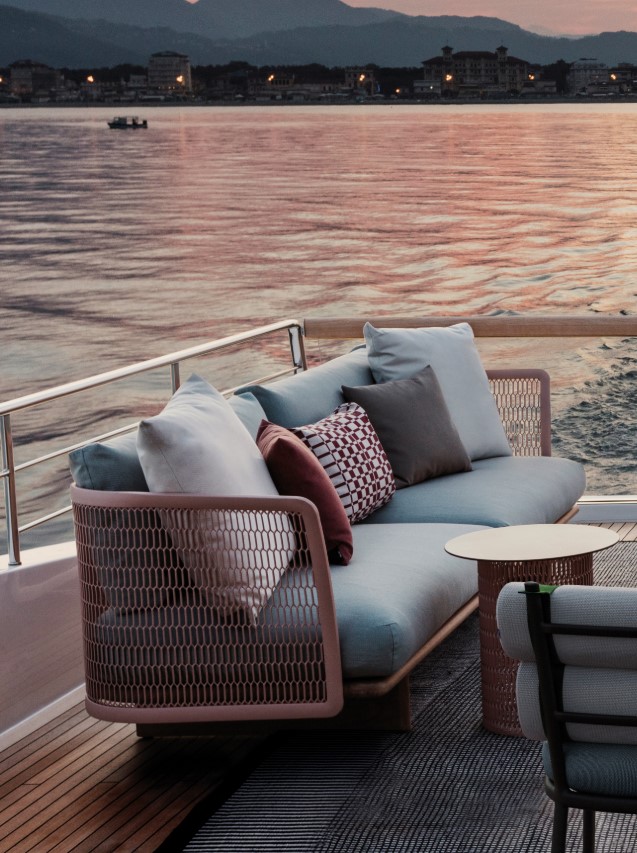 Comfortabele loungebank op een boot bij zonsondergang.