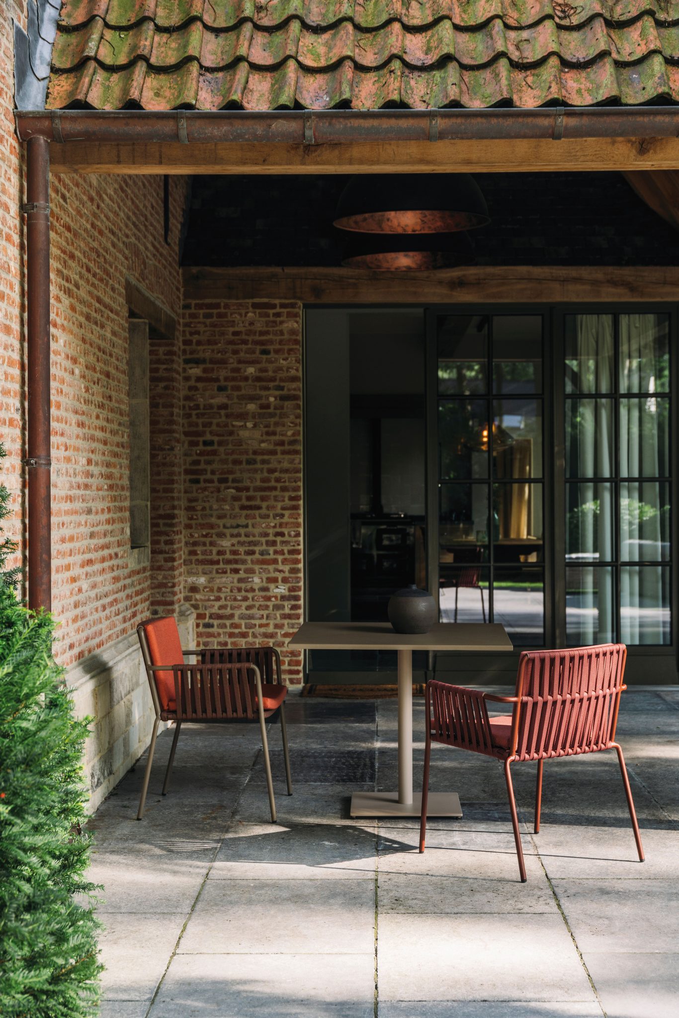 Terras met tafel en stoelen, bakstenen muur.