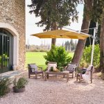 Tuin met zitgedeelte en parasol bij stenen huis