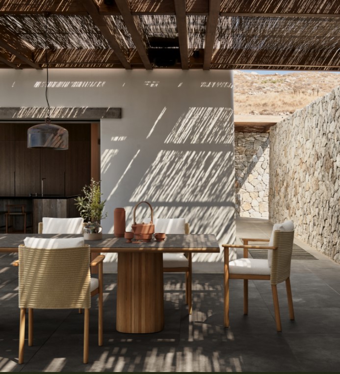 Buiten eetruimte met houten tafel en stoelen.